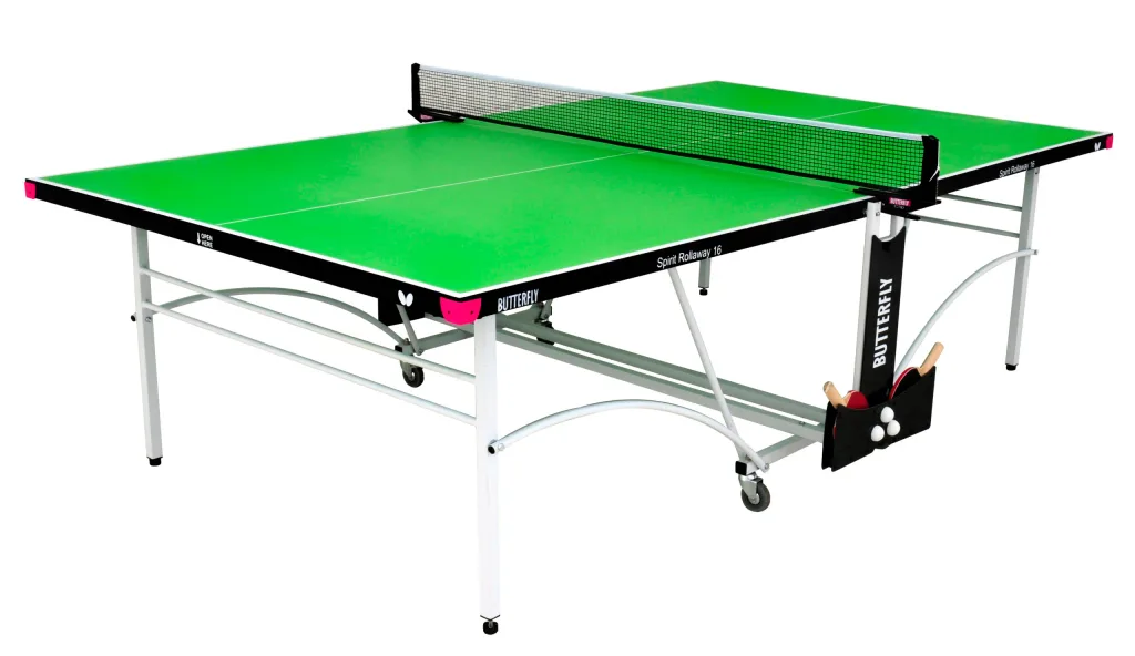 Table tennis table with a green playing top, magenta corner pieces and light silver legs and undercarriage, folding halves with a net and bat and ball holder.
