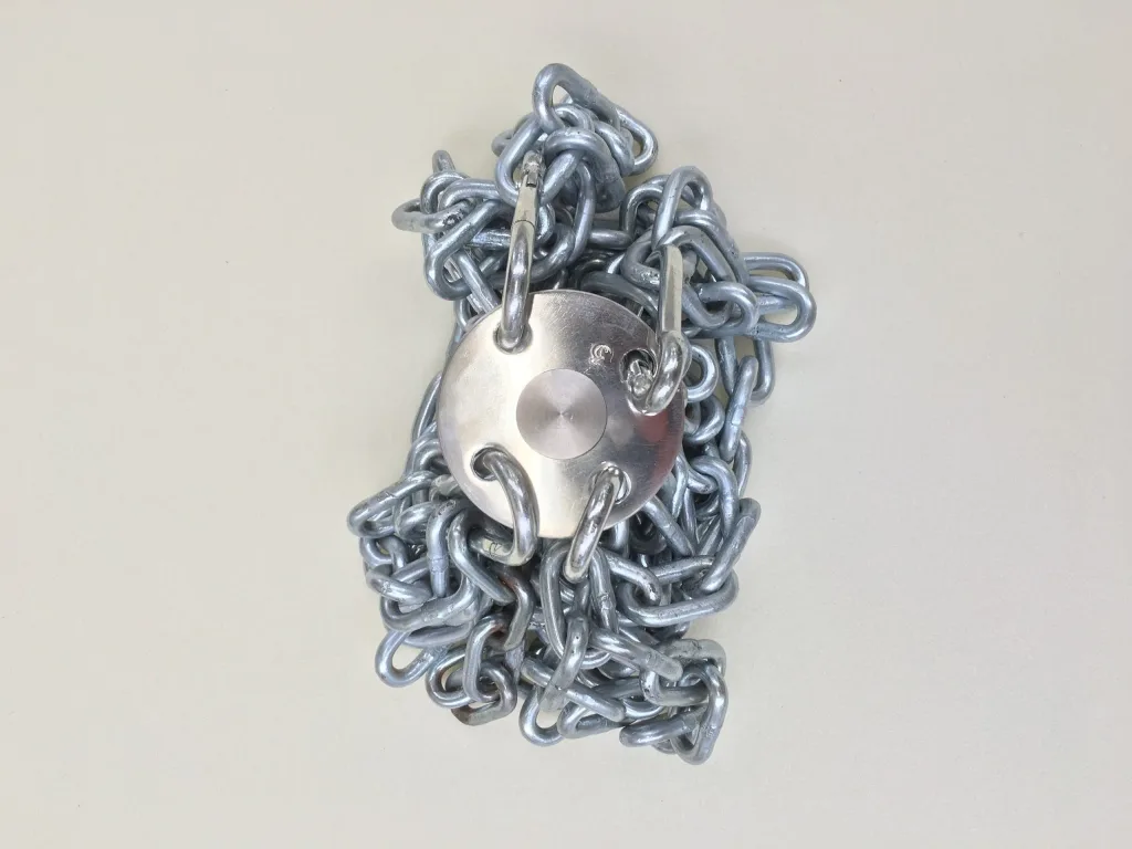 Coiled chain hammer with a circular head and four hooked attachments resting on a plain light background.