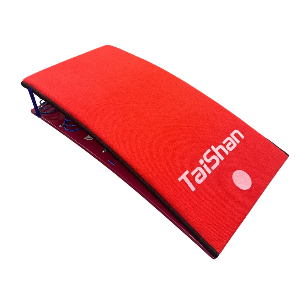 Red competition springboard with TaiShan logo and exposed blue springs under its curved padded top.