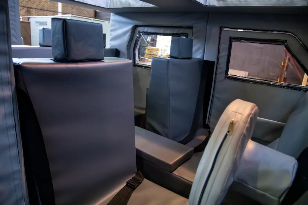 Padded training car interior with grey PVC-covered foam seats, headrests, double-stitched seams and built-in hiding places.
