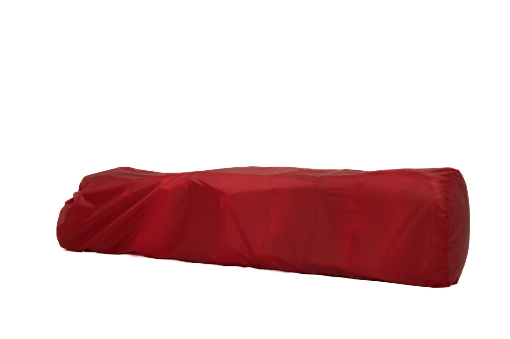 Long red fabric-covered cylindrical cushion on a white background.