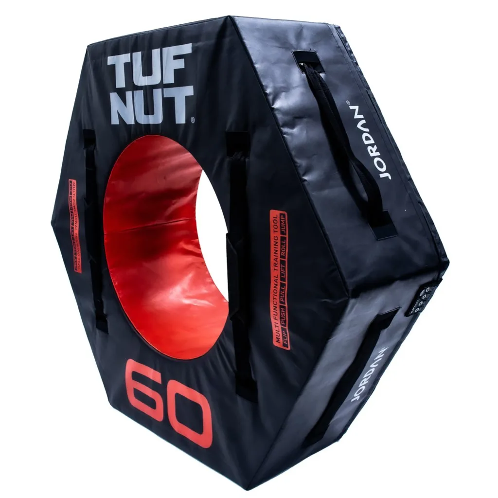 Black hexagonal training tyre with a red inner ring, carrying handles, and large text "TUF NUT", "60", and "JORDAN" on the face and side.