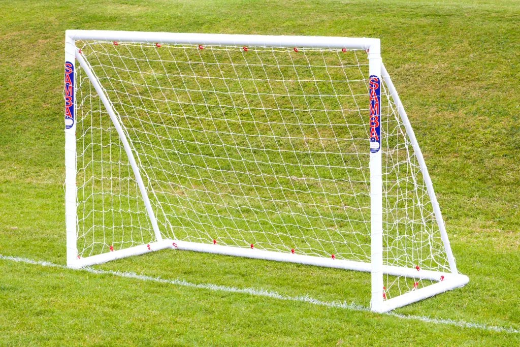 White Samba junior hockey/handball goal made from high-impact uPVC, freestanding on grass with white net and "SAMBA" labels.