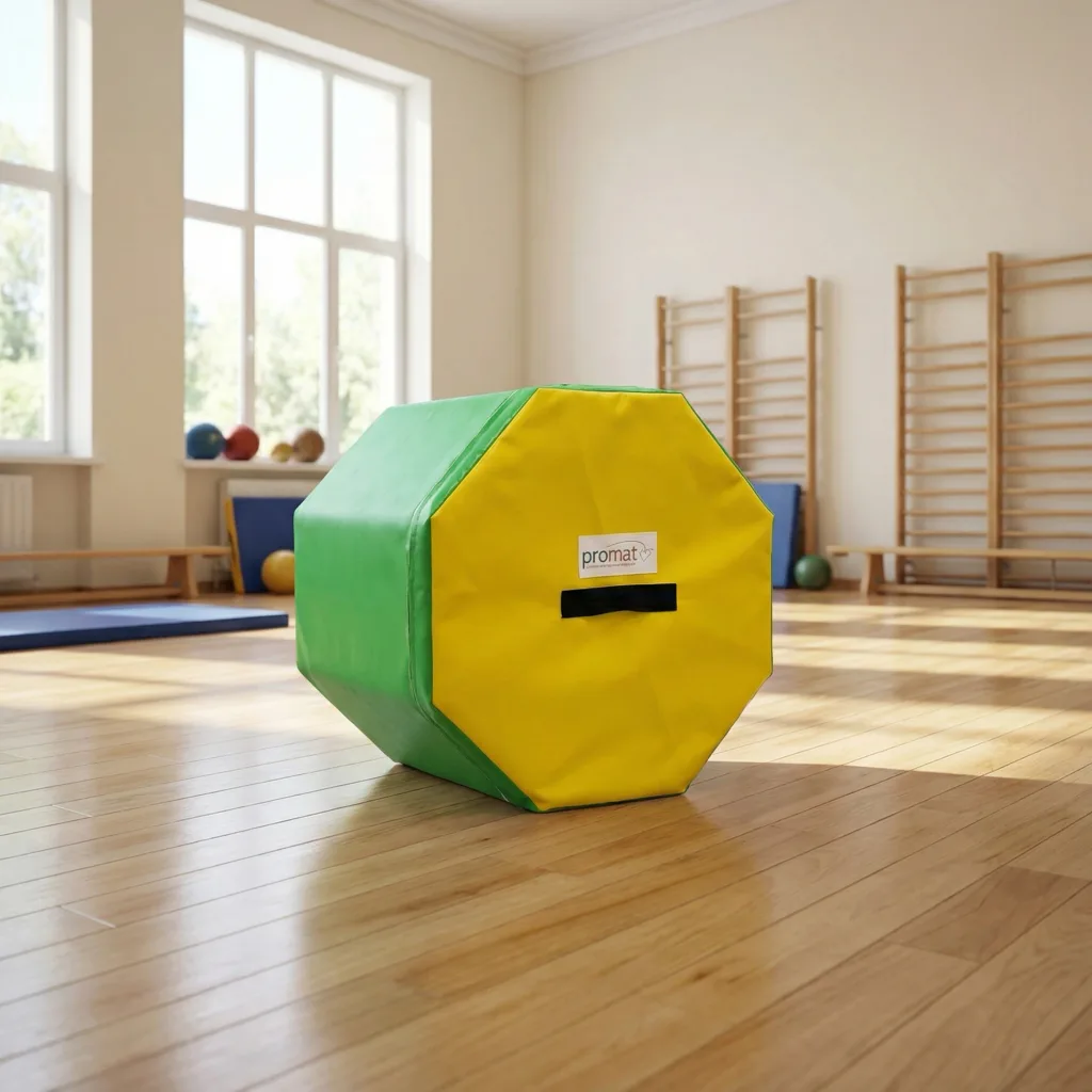 Octagonal high-density PU foam training block with green sides and yellow end in heavy-duty flame-retardant PVC, a black carry handle and a label reading promat, on a gym floor.