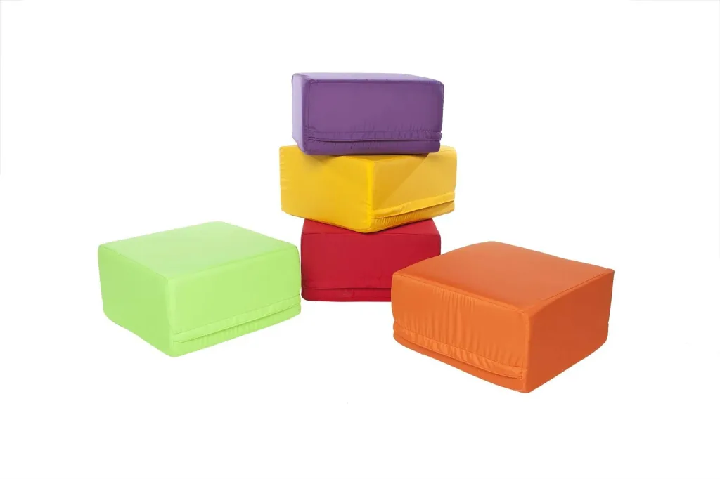 Five square cotton foam seating pods in purple, yellow, red, orange, and lime green arranged with two stacked in the center on a white background.