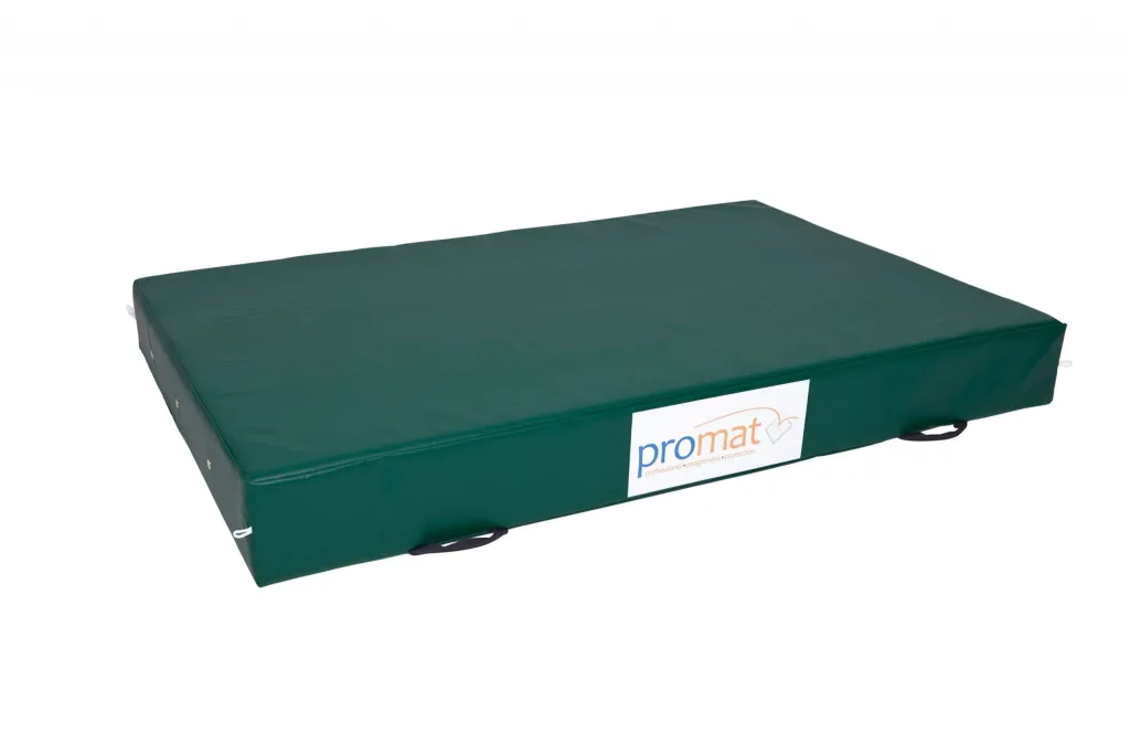 Green crash mat with zipped nylon-reinforced PVC cover, PU foam core, handles, anti-slip base and label reading 'promat'.