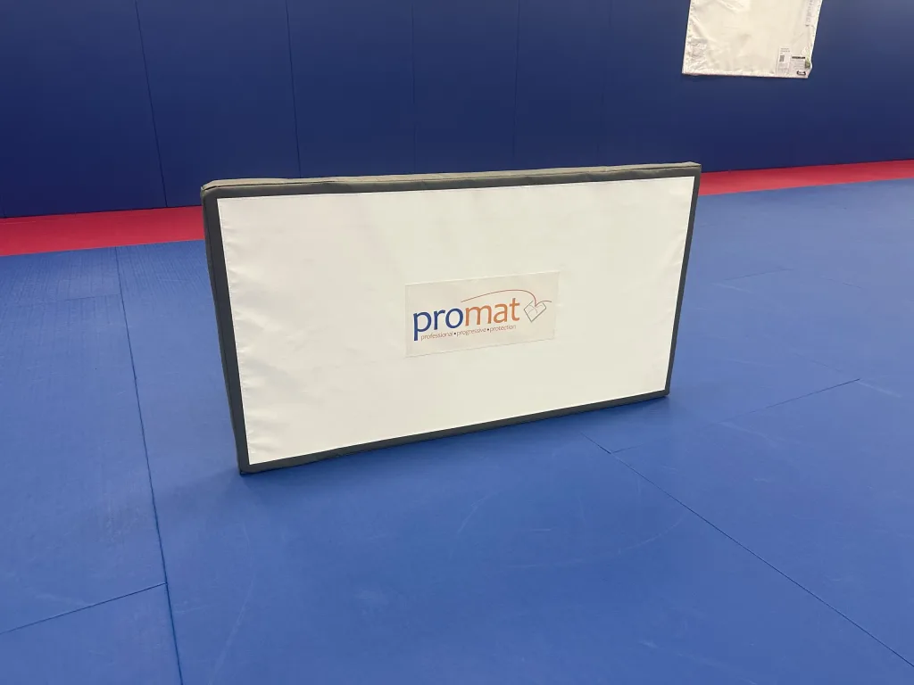 Closed-cell polyethylene TV screen and high-density PU foam stand wrapped in heavy-duty PVC with "promat" logo, on training mats.