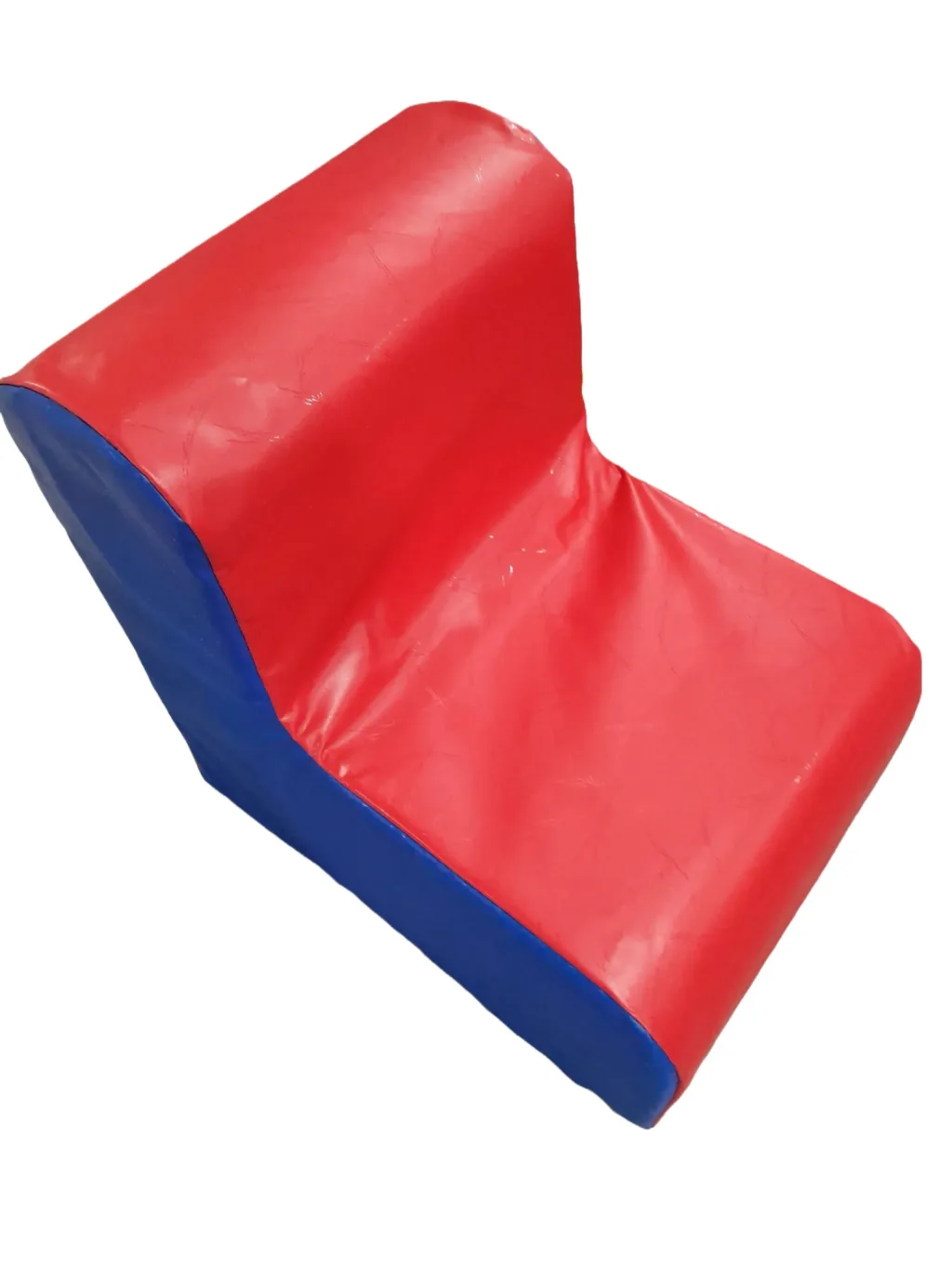 Foam-filled children's corner chair with red PVC cover and blue side panel, low seat and sloped back.