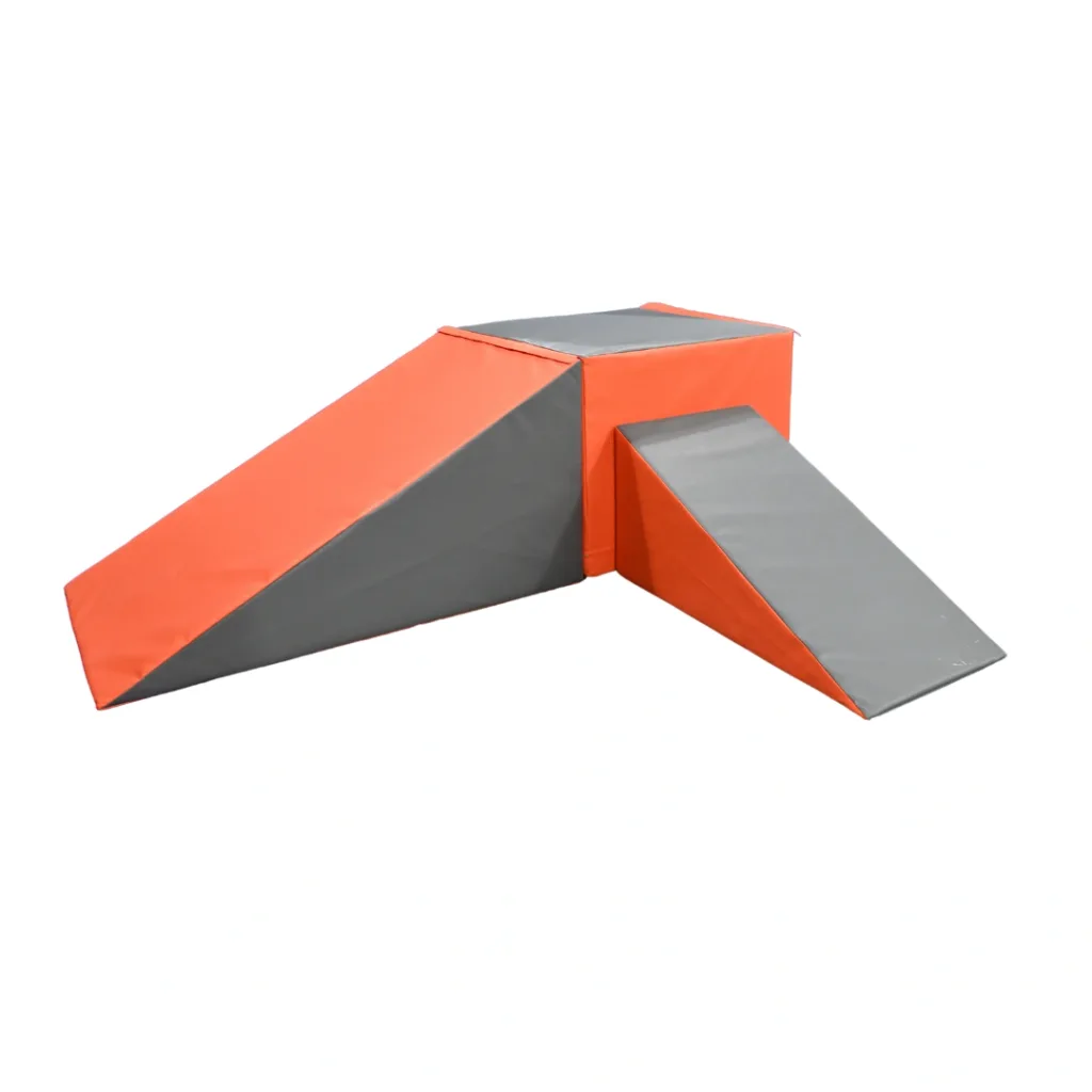 Five-piece foam gymnastics play set in orange and grey featuring a large wedge, small wedge and central cuboid arranged as bridges.