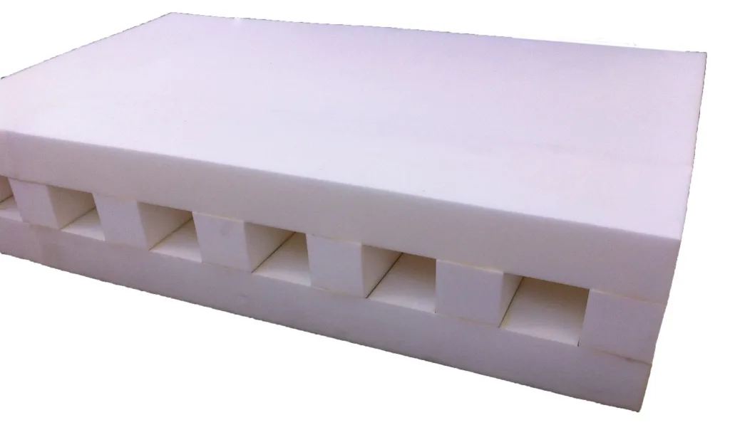 Layered foam block with castellated square cavities designed for high jump and pole vault replacement.