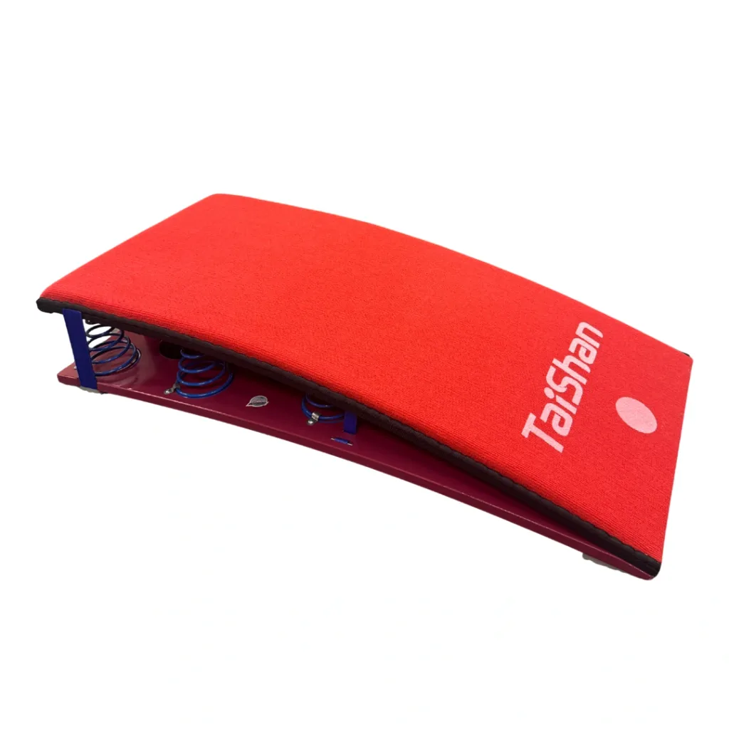 Red competition springboard with curved top, visible blue springs and Taishan printed on the surface.