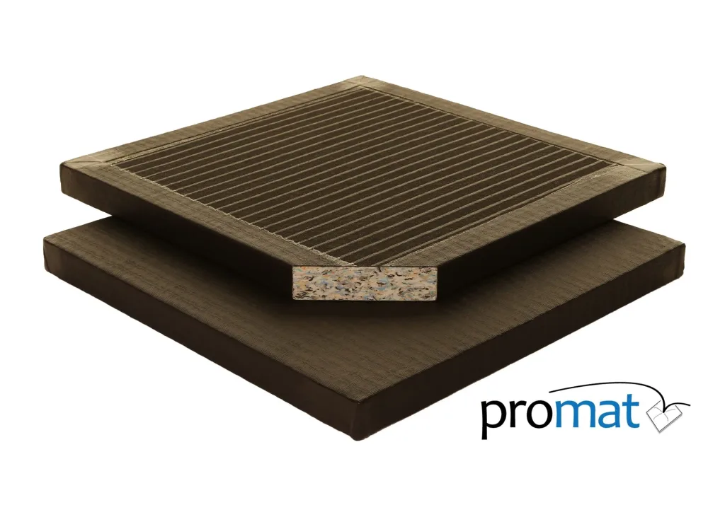 Two stacked black tatami PVC judo mats showing a multicolored chip-foam core cross-section and the word promat.