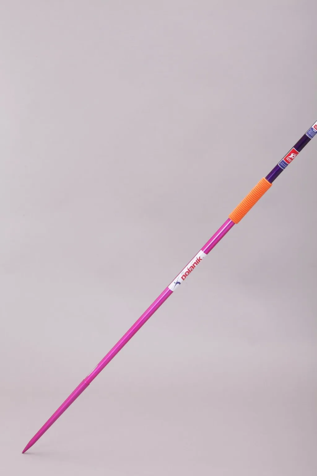 Purple javelin with an orange handgrip and steelhead, angled diagonally against a pale background.