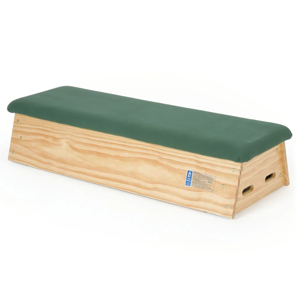 Vaulting box with a green quality hide padded top resting on natural timber sides with handle slots and visible fasteners.