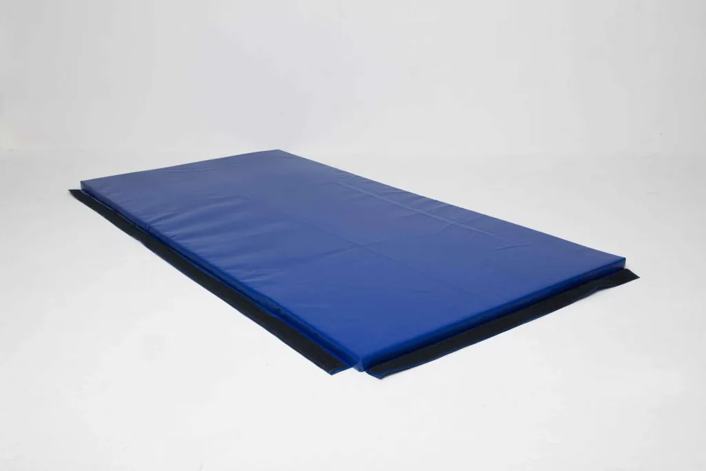 Blue rectangular gym mat with a sewn heavy-duty PVC cover and black anti-slip panels along the base.
