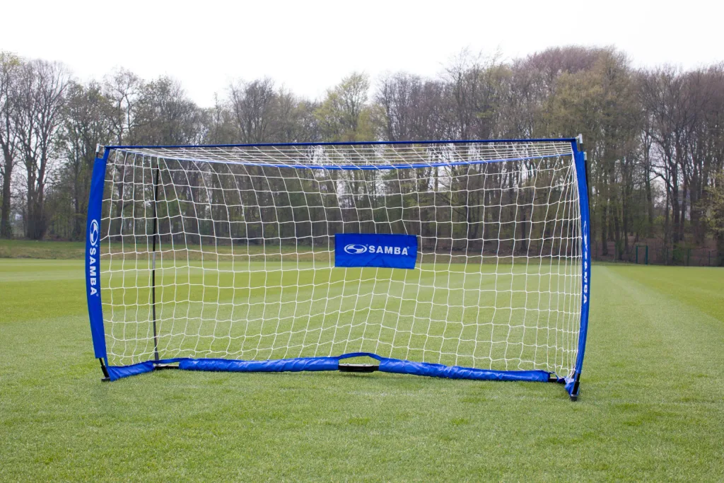 Blue foldable soccer goal with white net and center banner reading 'SAMBA' set on a grassy field.