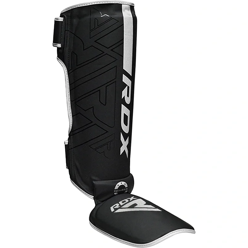 Black shin and instep guard with white trim, padded foot protector, and large RDX text on the front.