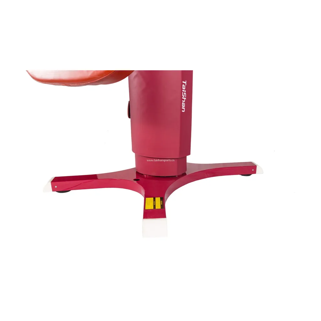 Red competition vaulting table base and central column with white foot caps and a partial padded top visible.