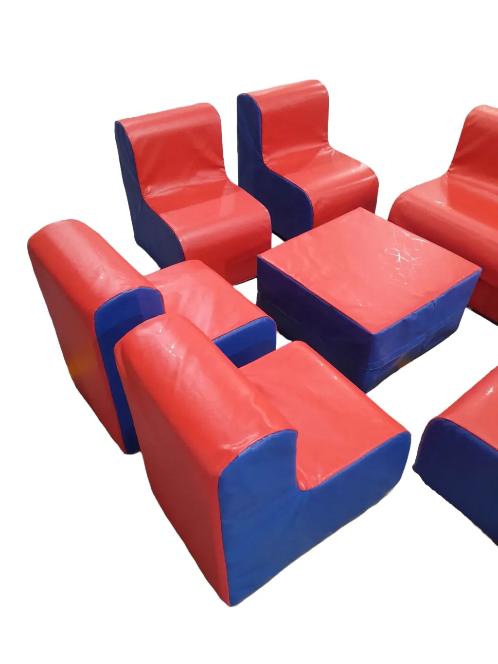 Children's furniture island set of foam-filled, PVC-covered pieces: two red-and-blue sofas, one chair, four wedge pouffes and a square ottoman.