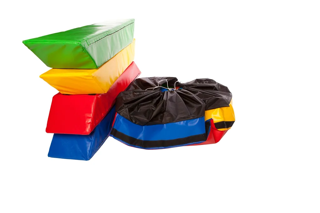 Toddler ball pool with four stacked foam walls in green, yellow, red, and blue next to a closed black drawstring liner with multicolored panels.