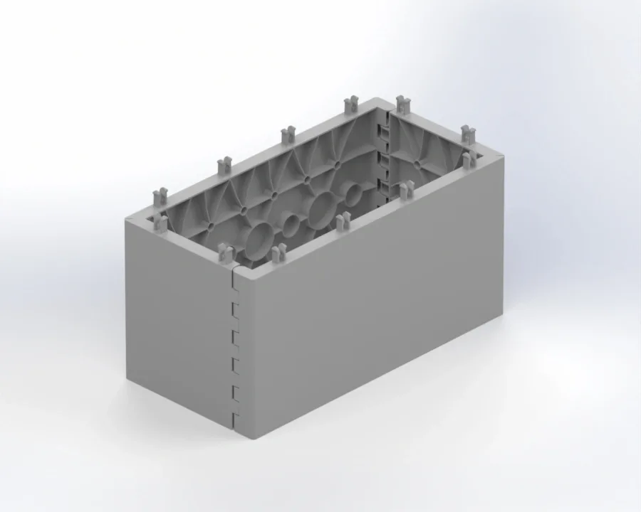 Rectangular gray hollow training block with internal ribbing, top peg connectors, and interlocking corner tabs for assembling modular walls.