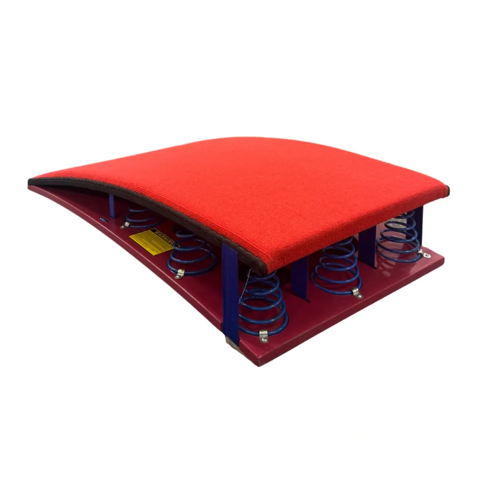 Red padded competition springboard with curved top, exposed blue coil springs and a magenta base.