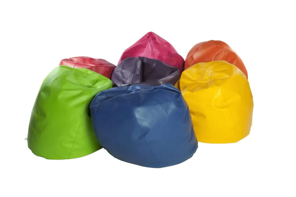 Giant children's faux leather bean bags in green, blue, yellow, orange, red, pink and purple arranged in a cluster.