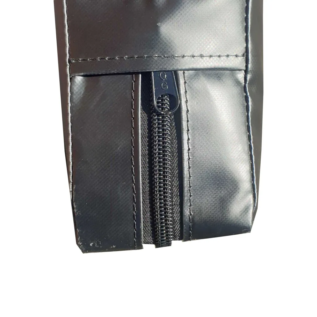 Close-up of a strike pad's heavy-duty PVC cover showing a vertical zipper with pull marked QG and reinforced stitched seams.