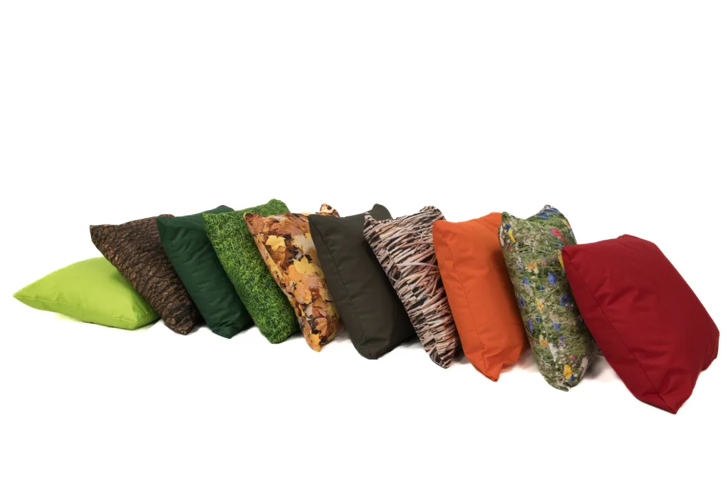 Ten coordinating scatter cushions with seasonal nature prints and solid colours lined up on a white background.
