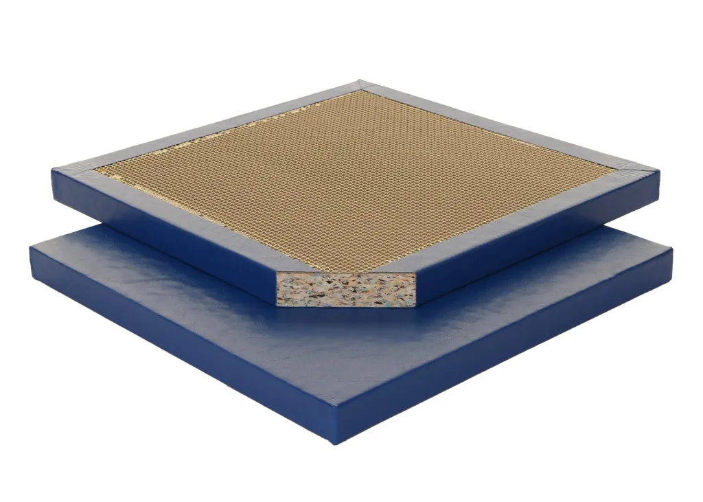 Royal blue mat with a smooth polyester PVC frame surrounding a tan cellular waffle center and a corner cutaway revealing the recon foam core.