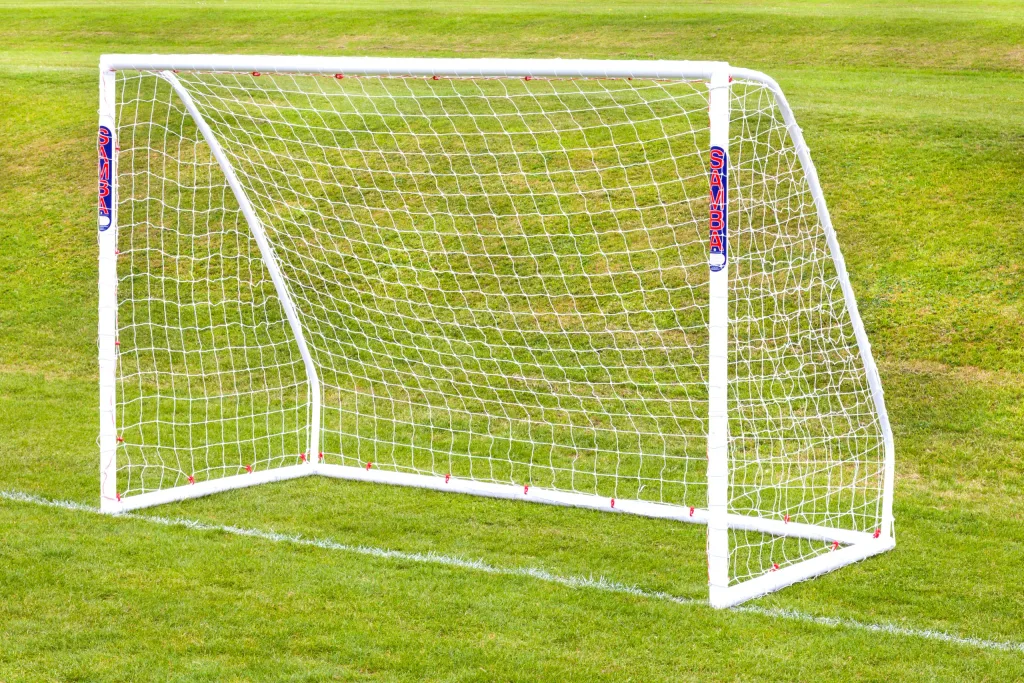 White high-impact uPVC freestanding soccer goal with net on a grassy field, SAMBA printed on the posts.
