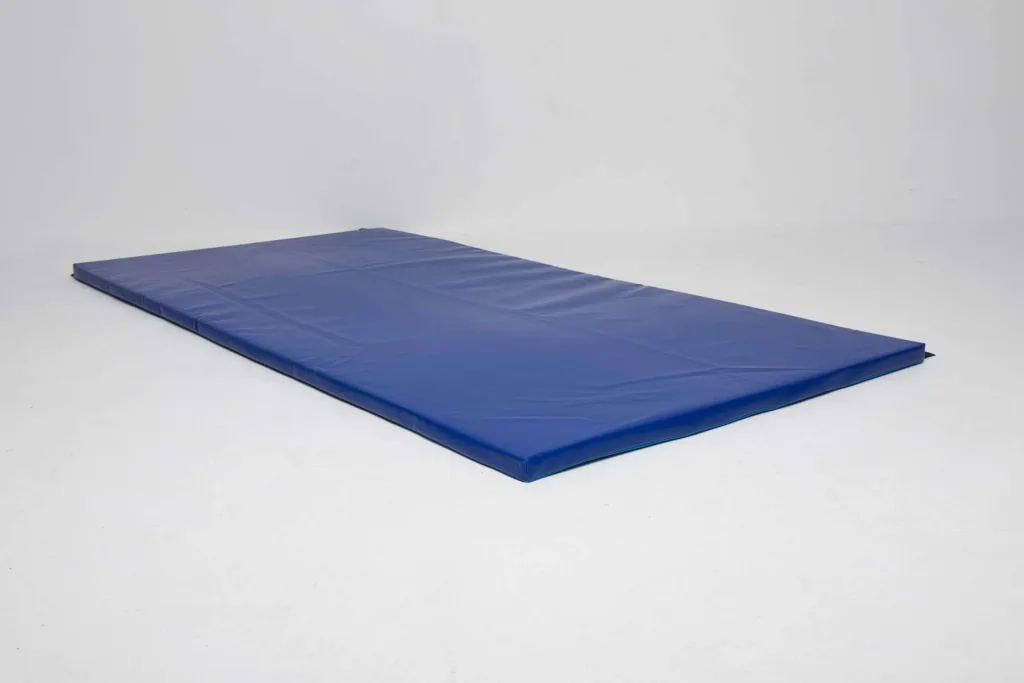 Blue heavy-duty lightweight gym mat with a sewn tear-resistant PVC cover and anti-slip base lying flat on a white floor.