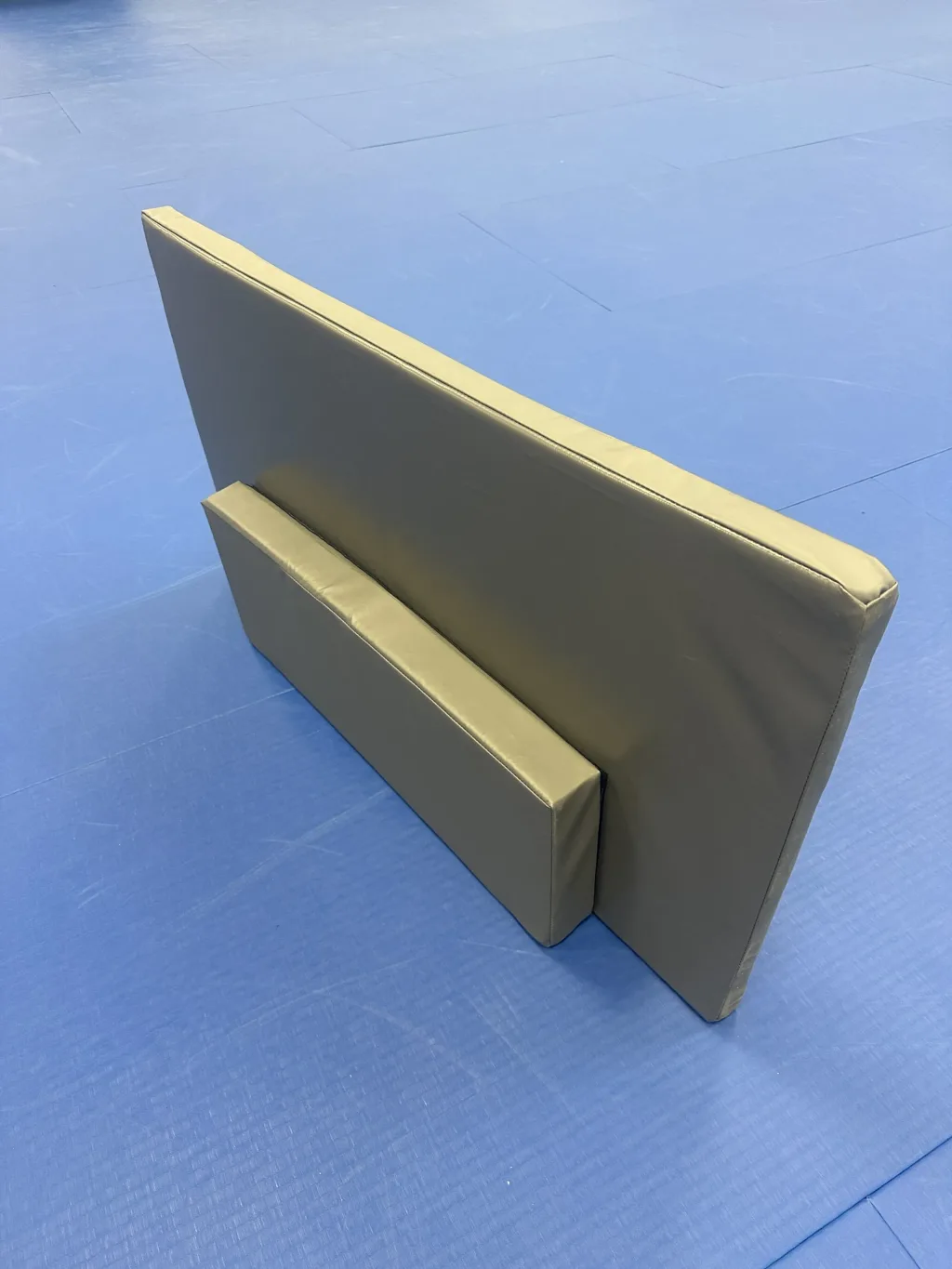 Foam TV screen (closed-cell polyethylene) and foam TV stand (high-density PU) with grey PVC covers standing on a blue training mat.
