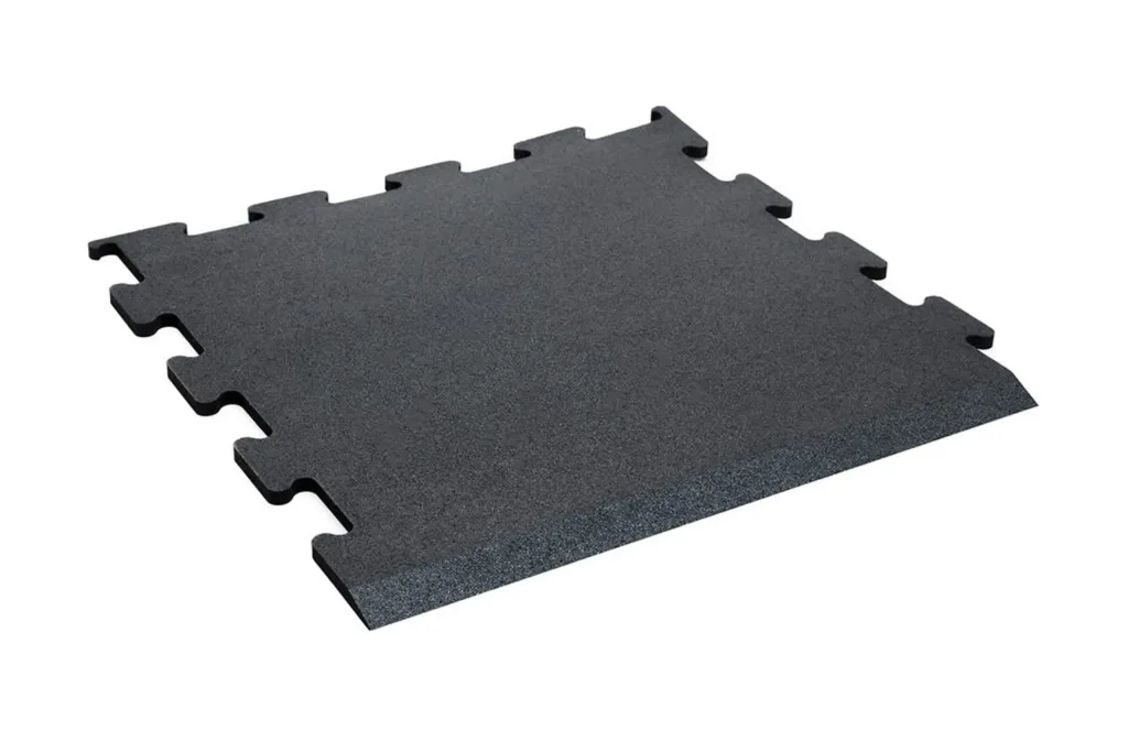 Dark grey interlocking tile with puzzle edges, textured surface and a beveled ramp on one side.