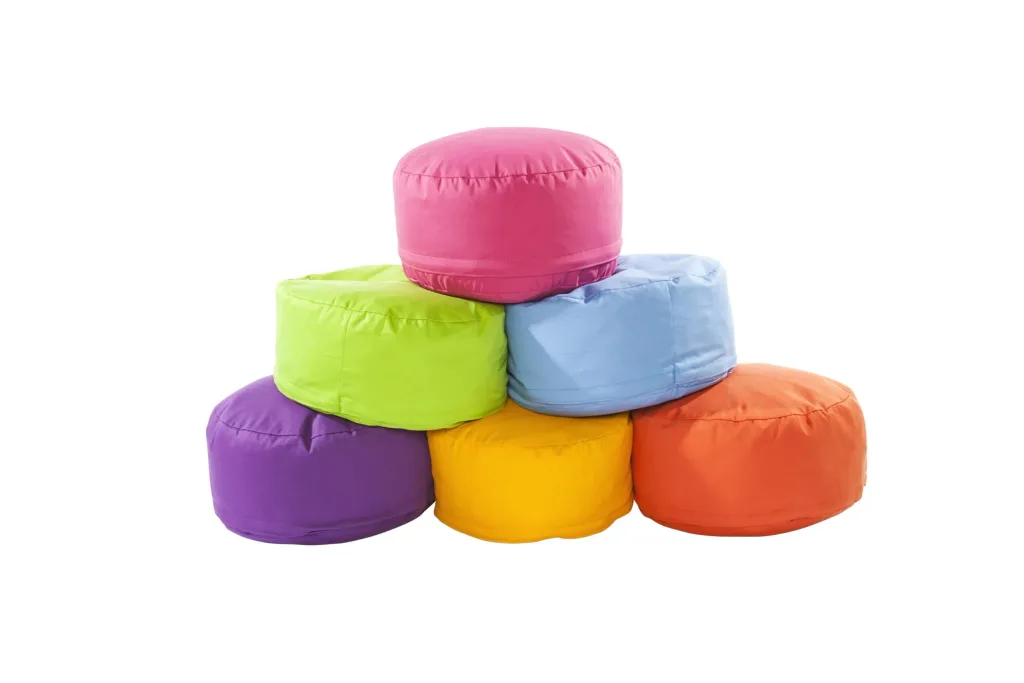 Six round cotton bean pods stacked in a pyramid, in pink, lime green, light blue, purple, yellow and orange.