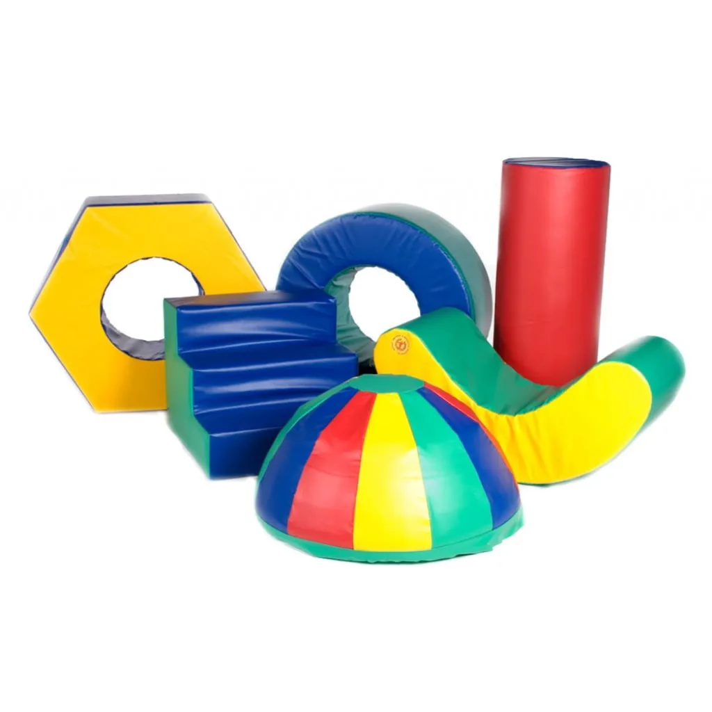 Colorful foam play set with yellow hexagon ring, blue step block, blue-green donut, red cylinder, green-yellow curved wedge, and multicolored dome.