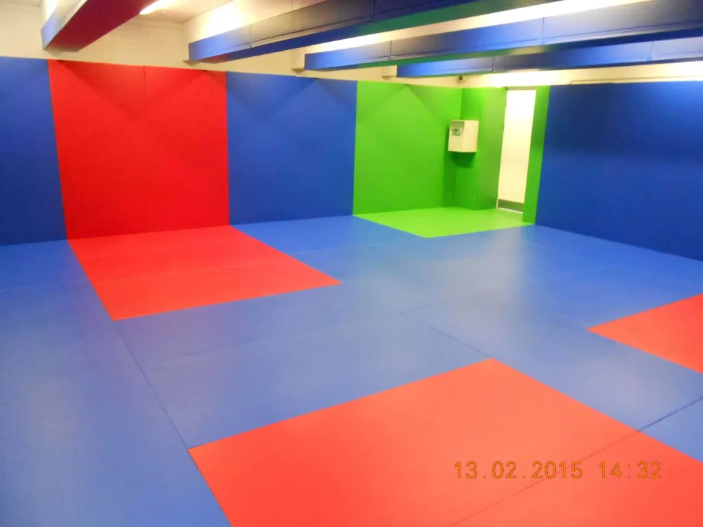 Padded control room with blue floor and walls, red and green padded zones, ceiling beams and the text 13.02.2015 14:32.
