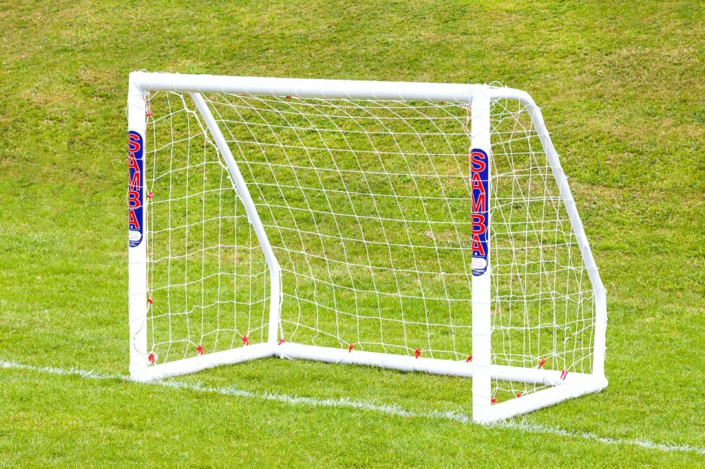 White freestanding uPVC soccer goal with net on grass, vertical SAMBA labels on the posts.