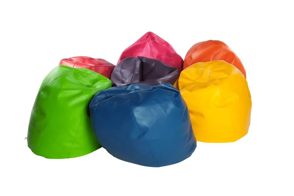 Giant children's faux leather bean bag in blue at the front with green, yellow, orange, pink, and purple bean bags grouped behind it.
