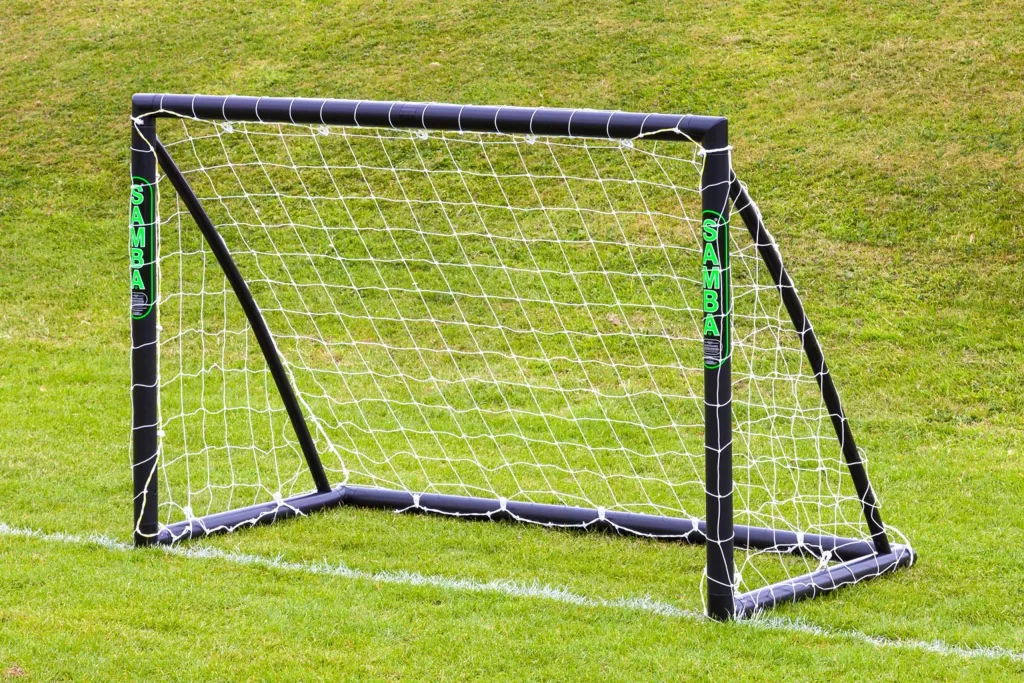 Freestanding black uPVC training soccer goal with white net and "SAMBA" printed vertically on the posts, set on grass.