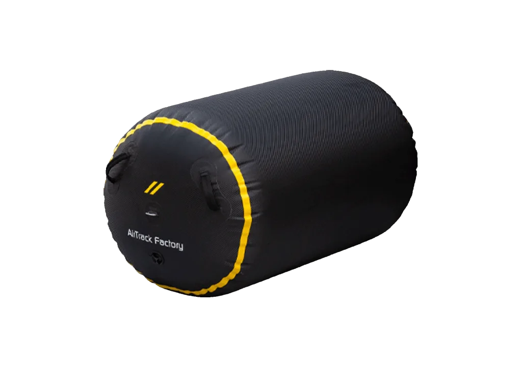 Black cylindrical inflatable roll with yellow trim and two handles, end showing text "AirTrack Factory".