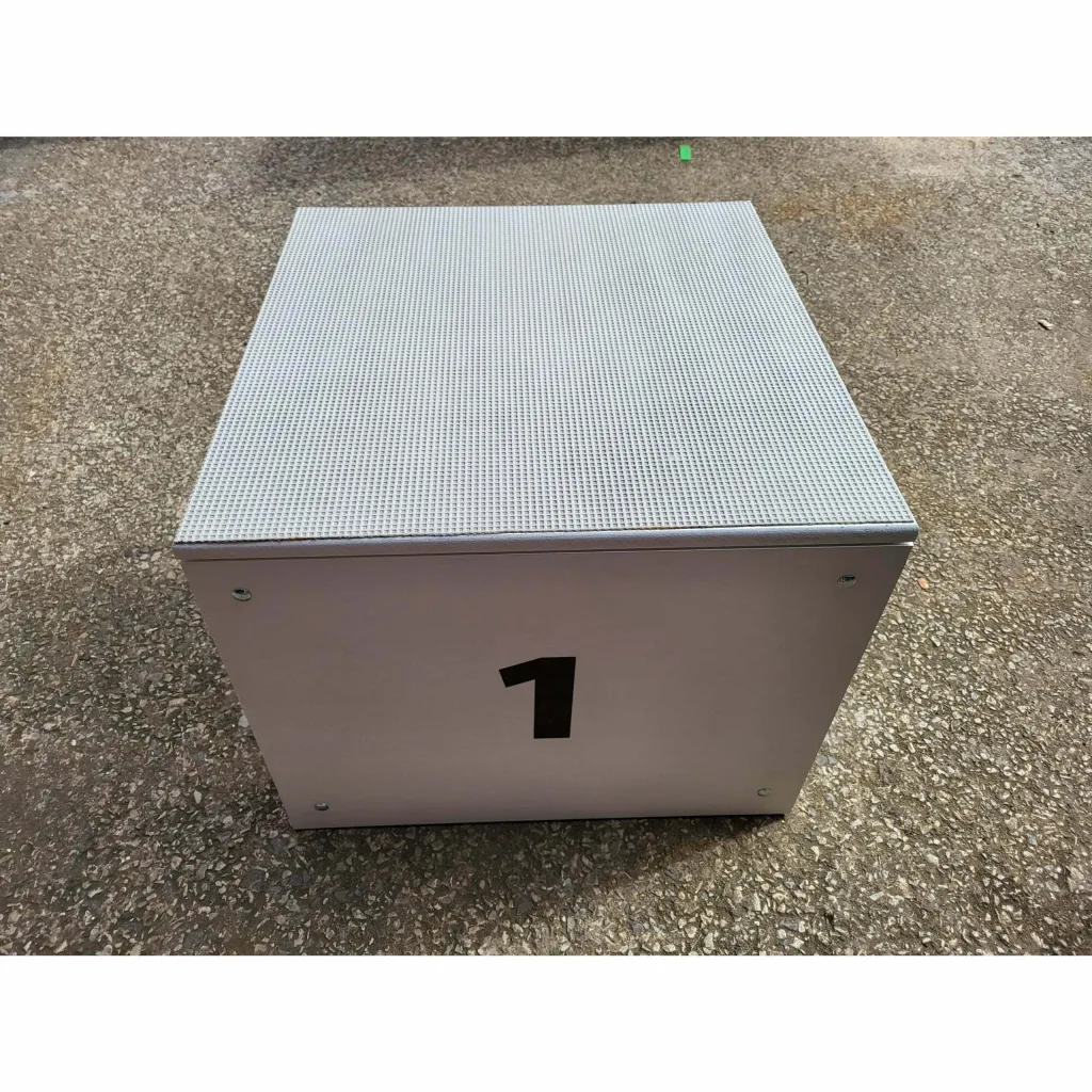 Winners podium box labeled 1 with textured top sitting on rough asphalt.