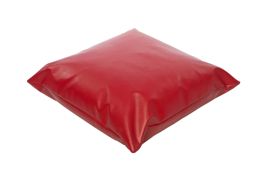 Child reading cushion in red faux leather, square and plump with polybead filling and a removable cover.