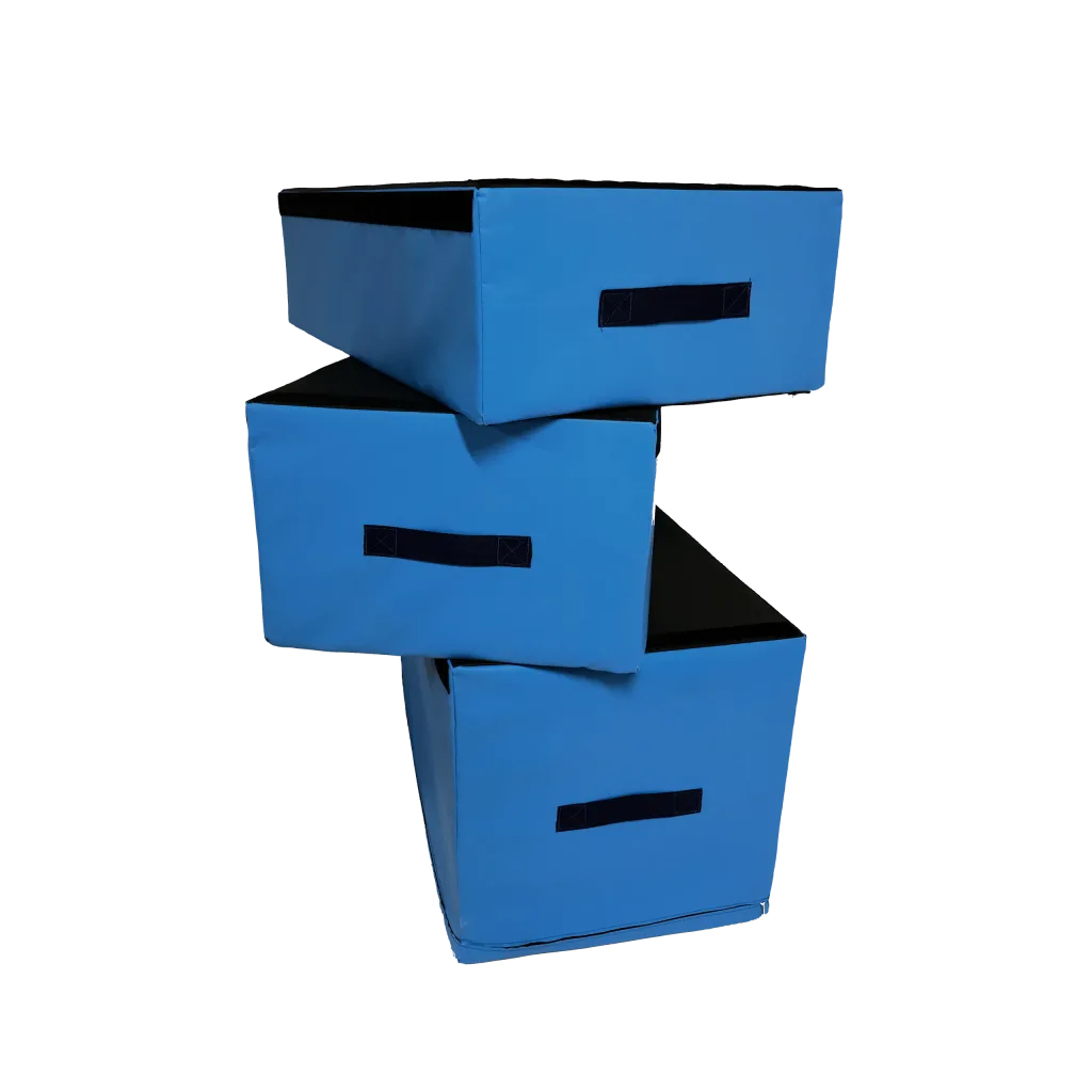 Three blue PVC-covered rectangular jumping blocks stacked offset, each showing a black carry handle and black top.