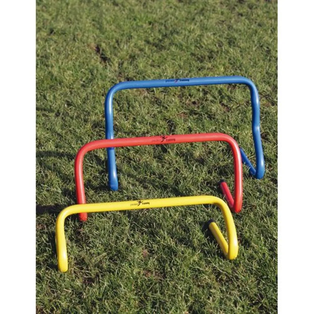 Three low agility hurdles in blue, red, and yellow arranged in a staggered row on grass.