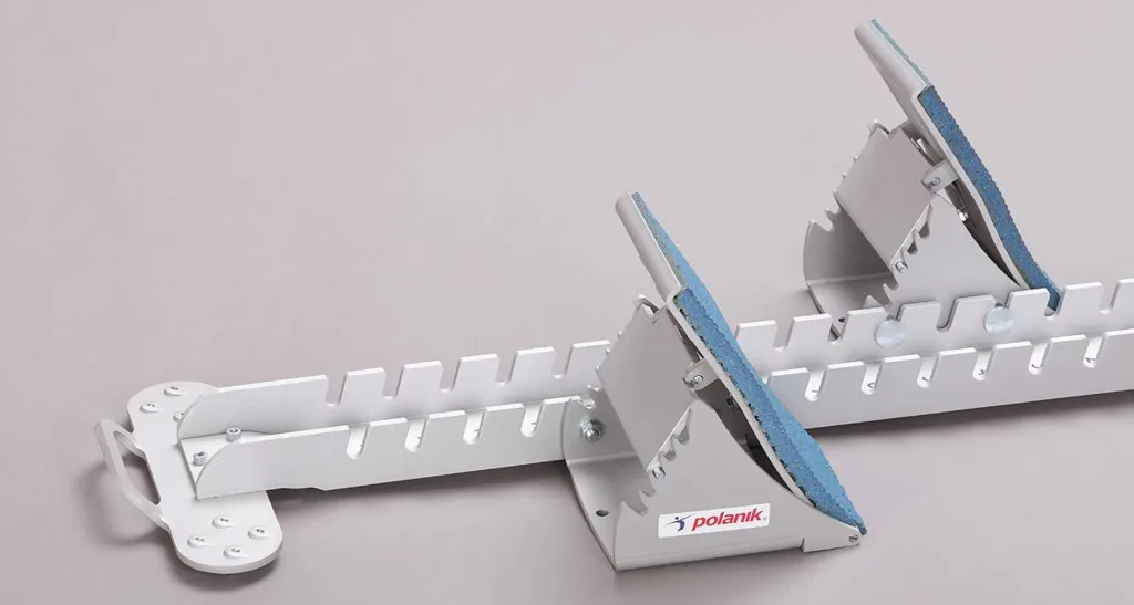 Aluminium competition starting block with two adjustable foot supports covered in blue synthetic track and the text polanik on the base.