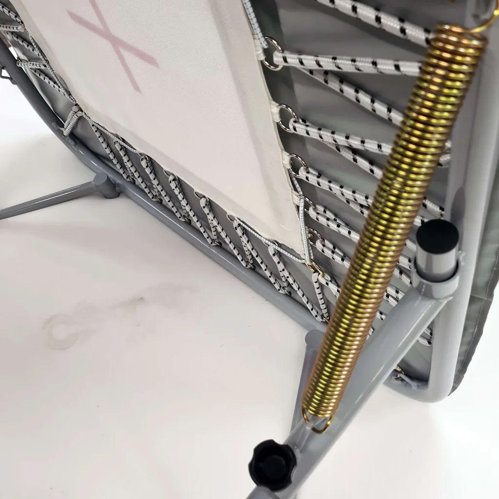 Underside view of a mini tramp with a zinc-plated steel tube frame, webbed bed, coiled steel spring, and nylon-reinforced PVC foam pads.
