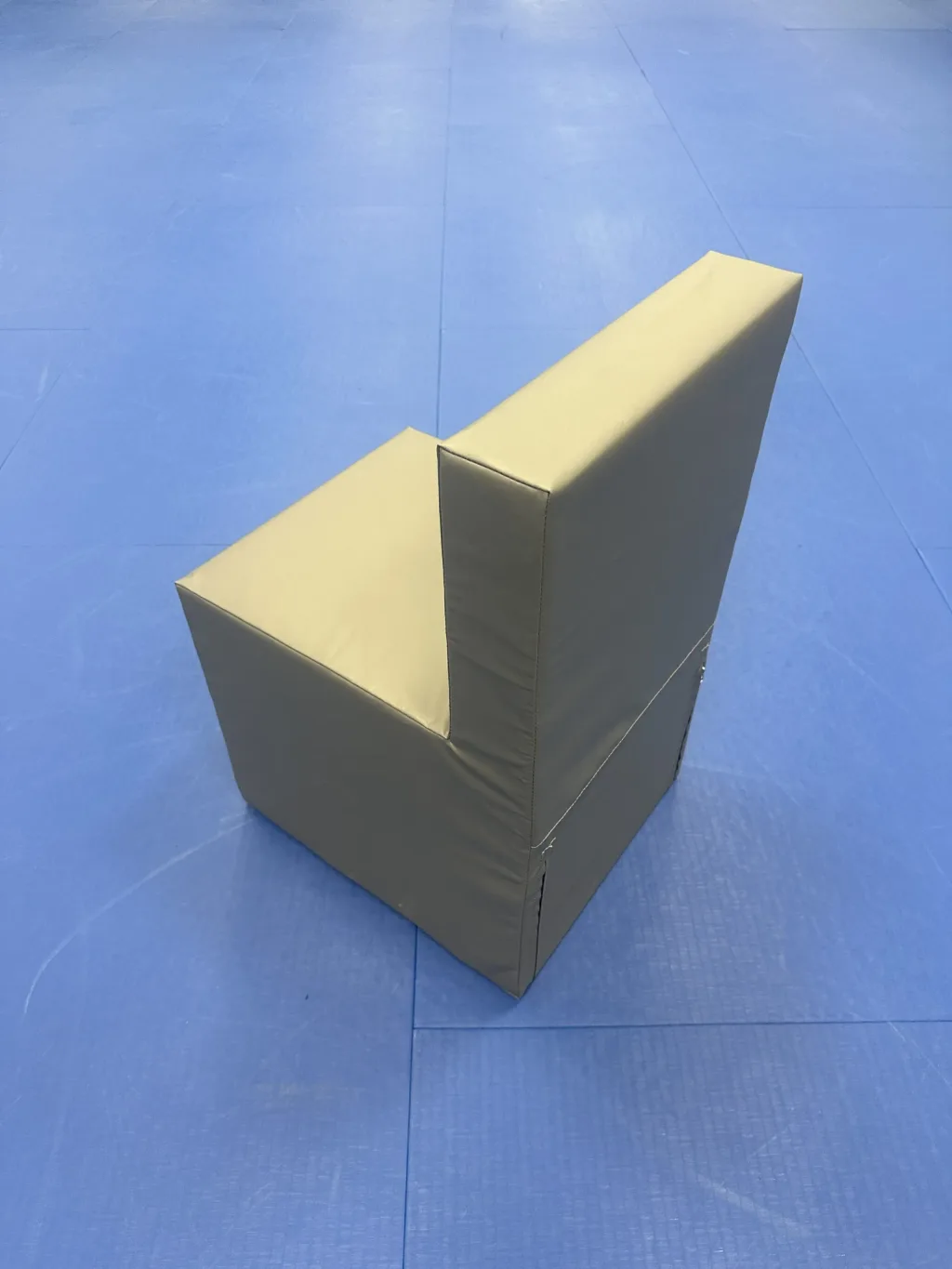 Single foam chair with tear-resistant PVC cover and high-density foam core, light grey, positioned on blue mat flooring.