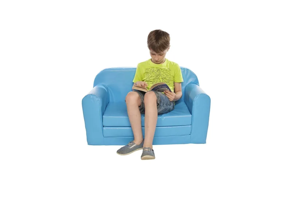 Boy sitting on a snug sofa bed with PVC cover, reading a book.