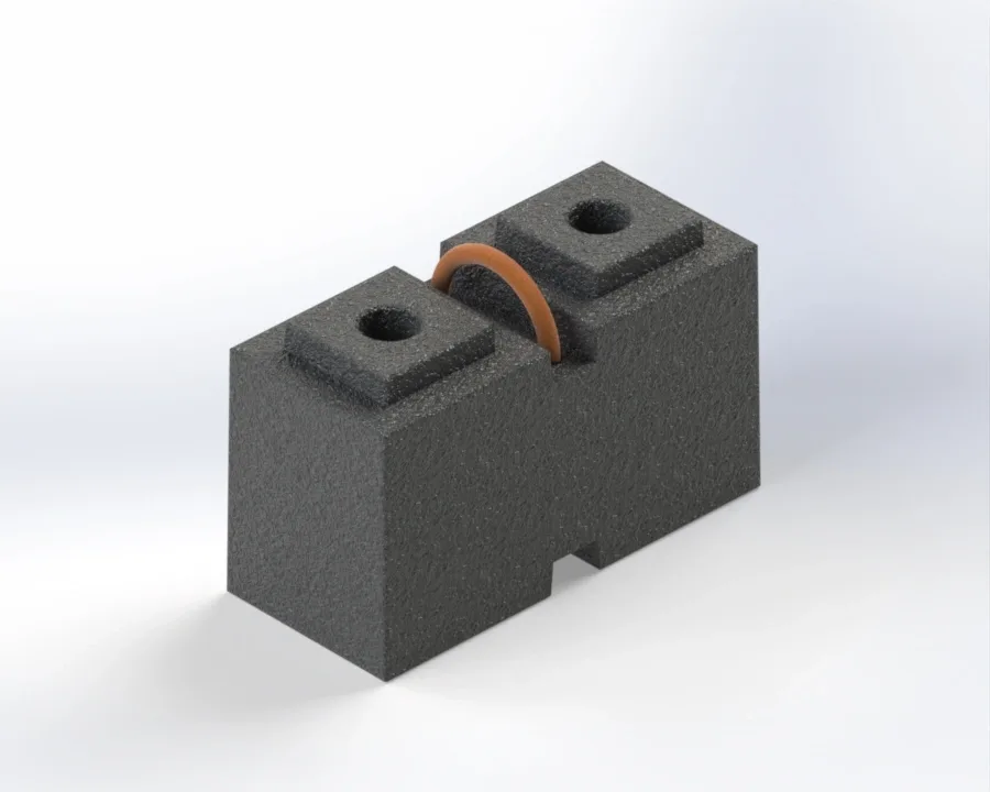 Dark gray foam block with two raised square tops each with a circular hole and a central slot holding a brown looped connector.